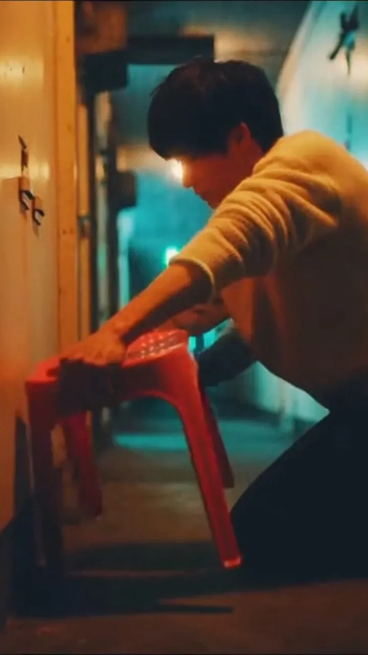 9 seconds total, 1990s Tokyo Japan urban nostalgic cinematic texture, neon-lit rainy night, heavy film grain, overlapping cool blue and warm red neon glows, intensely earnest character performances, atmosphere of fated reunion
0-2s: Flashback, close-up shot in the corridor of an old Shimo-Kitazawa residential apartment building, the young male lead fixes a wobbly falling-apart red plastic stool, slides it gently back against the wall
3-6s: Present day, outside a late-night convenience store on a rainy night, a woman in a dark trench coat walks slowly out of the neon puddle reflections, steps in to block a flying umbrella and cardboard box from hitting the male lead, shot executes a slow dolly in, mood is solemn as if the pair are reuniting after years apart
7-9s: The male lead whispers quietly "Are you the old acquaintance from all those years ago?" The woman replies calmly "No. I am that plastic stool you fixed." The next second she transforms back into the red plastic stool, trips him lightly, the male lead falls to the ground in a flustered heap, forming a deadpan absurd comedy
All characters are original fictional creations, not based on any real-life celebrities or public figures, no imitation of any real person's facial features, no recognizable celebrity traits present; faces are low-recognition, archetypal, non-realistically rendered, no overemphasis on detailed facial features
Prohibited elements firearms fight scenes chases criminal content police-related elements subtitles logos watermarks